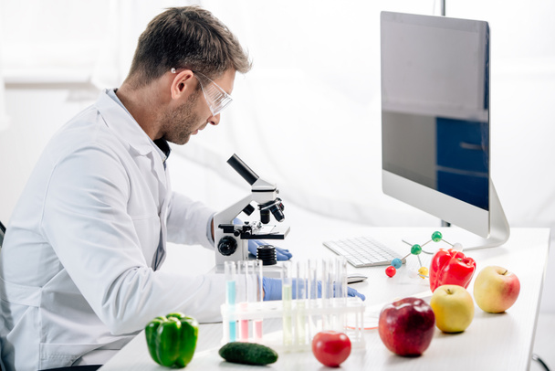 side view of molecular nutritionist using microscope in lab  - Photo, Image