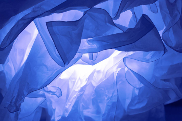 abstrakte defokussierte Hintergrundkulisse, zerknülltes Papier. Farbe des Jahres 2020 klassischen blauen Hintergrund Hintergrundtapete, Foto in trendigen blauen Farbe getönt - Foto, Bild