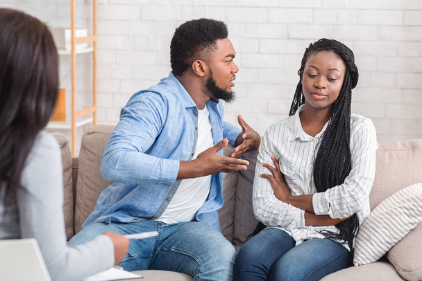 Irritado homem negro culpando sua esposa indiferente durante terapia sessão de aconselhamento
 - Foto, Imagem
