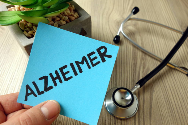 Palabra de Alzheimer escrita a mano en nota adhesiva azul
 - Foto, imagen