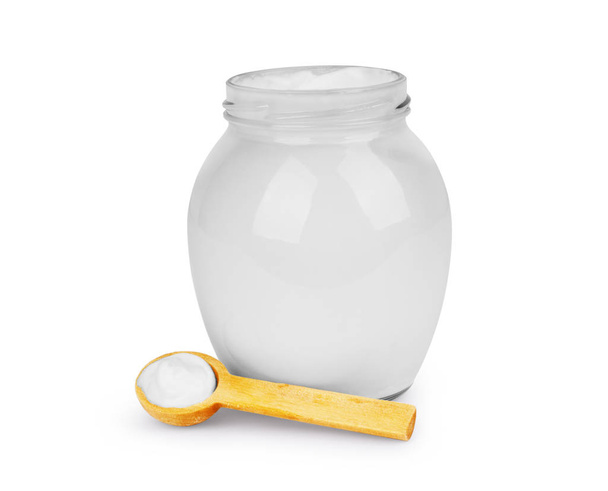 Sour cream in a glass jar with a spoon on a white background - Photo, image