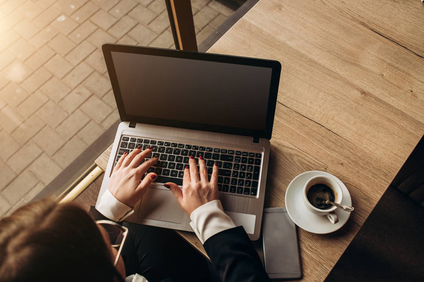 una donna d'affari con gli occhiali da sole che lavora al computer portatile nel caffè
 - Foto, immagini