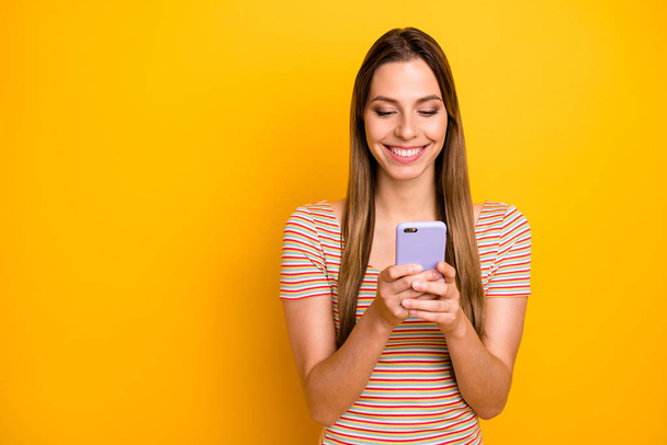 I love you. Photo of funny pretty lady hold telephone hands reading handsome guy sms love confession wear casual striped t-shirt isolated yellow color background - 写真・画像