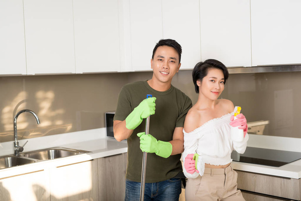 Feliz joven asiática pareja limpieza cocina juntos
 - Foto, Imagen
