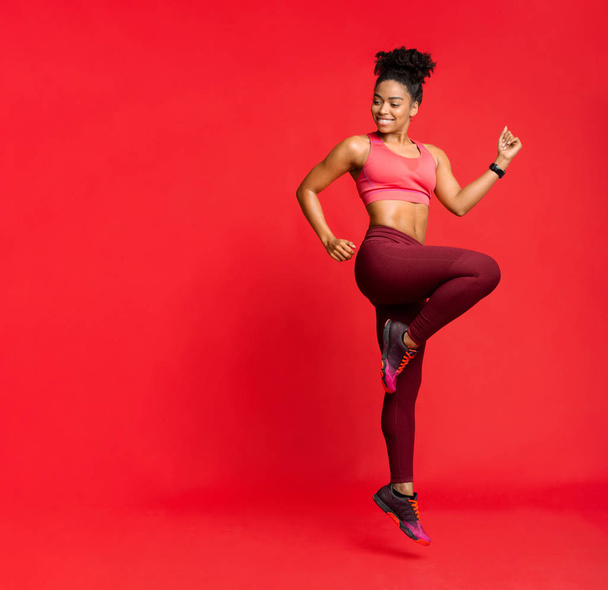 Joyful sporty african girl exercising, looking at free space - Foto, imagen