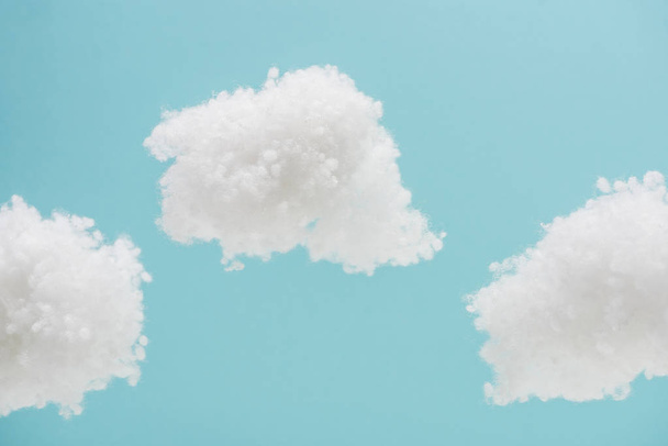 białe puszyste chmury wykonane z wełny bawełnianej izolowane na niebieskim tle - Zdjęcie, obraz