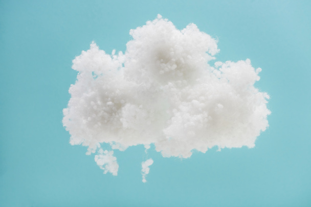 witte pluizige wolk van katoenen wol geïsoleerd op blauwe achtergrond - Foto, afbeelding