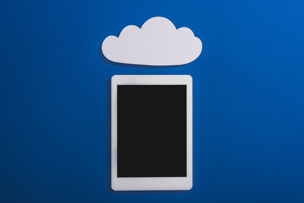 vista superior da nuvem de papel branco vazia perto do tablet digital com tela em branco isolada em azul
 - Foto, Imagem