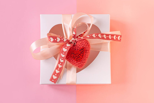 Witte geschenkdoos met hartvormig venster en kaartlabel op pastelpaarse achtergrond plat, creatief minimaal concept. - Foto, afbeelding
