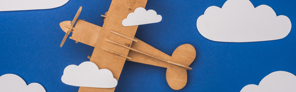 top view of wooden plane in blue sky with paper cut white clouds, panoramic shot - Photo, Image