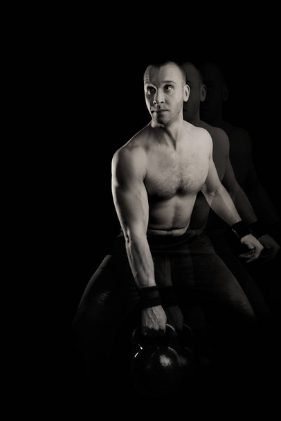 Kettlebell man. Man with weight on a black background - Photo, Image