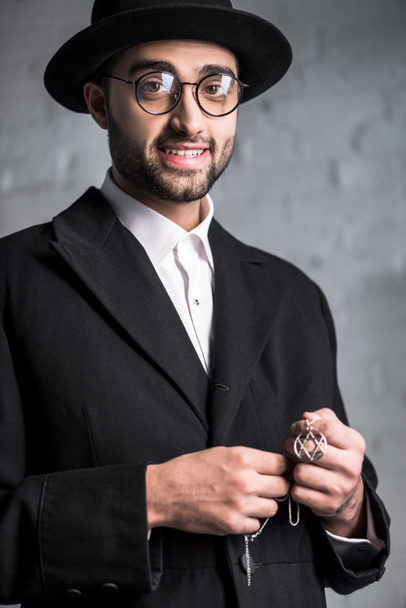 bello e sorridente uomo ebreo in occhiali con in mano stella della collana David
  - Foto, immagini