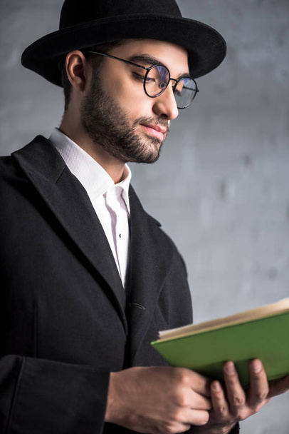 handsome and young jewish man in glasses reading book  - Photo, Image