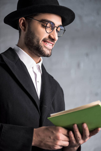 homem judeu bonito e sorridente em óculos livro de leitura
  - Foto, Imagem