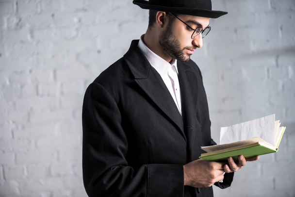 pohledný a mladý Žid muž v brýlích čtení knihy  - Fotografie, Obrázek