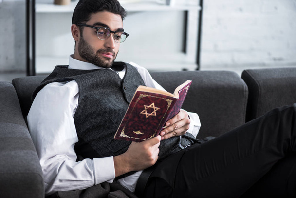 handsome and young jewish man in glasses reading tanakh  - Photo, Image