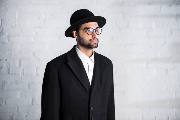 handsome jewish man in glasses and hat looking away  - Фото, изображение
