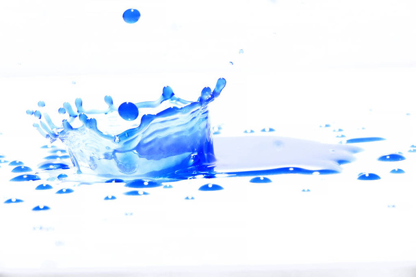 Blaues Wasser plätschert auf weißem Hintergrund, Fotografie. Blaues Wasser spritzt. - Foto, Bild