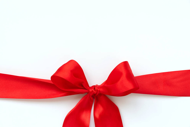 Red ribbon bow isolated on white background. Valentines day or birthday celebration concept. Top view - Фото, зображення