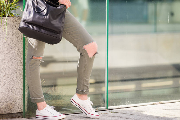 Женщина в зеленых брюках с дырками на коленях
 - Фото, изображение