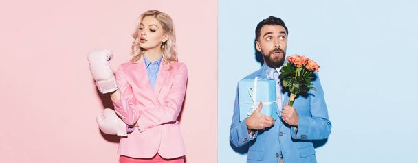 panoramic shot of serious woman with boxing gloves and scared man with gift and bouquet on pink and blue background  - Photo, Image