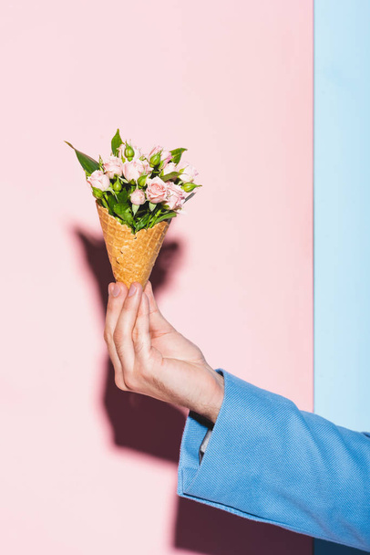 cropped view of man holding bouquet on pink and blue background  - Valokuva, kuva