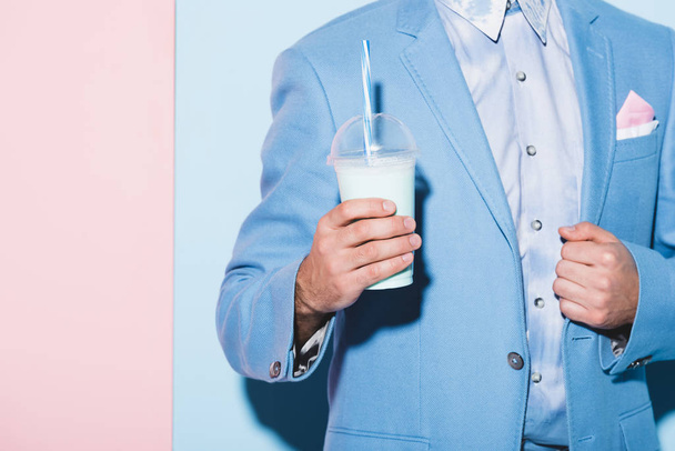 cropped view of man holding cocktail on pink and blue background  - Φωτογραφία, εικόνα