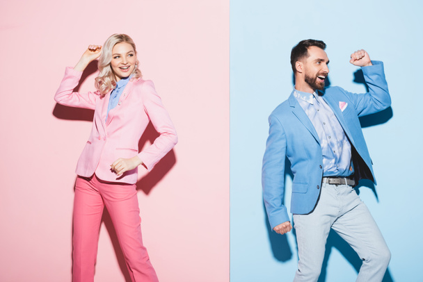 mosolygós nő és jóképű férfi mutat igen gesztus rózsaszín és kék háttér  - Fotó, kép