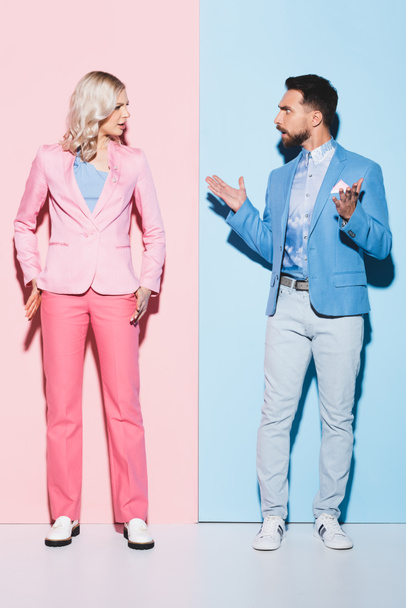 angry woman and handsome man quarreling on pink and blue background  - Foto, Imagem