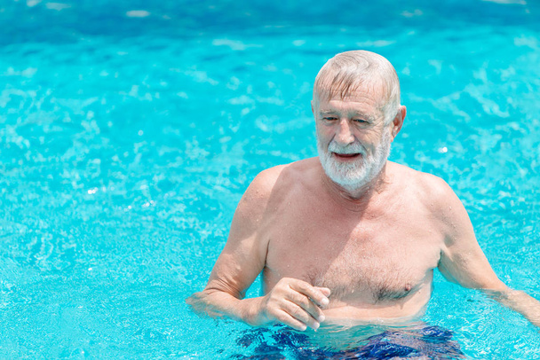 Ancien vieil homme nageant dans la piscine vacances seul
. - Photo, image