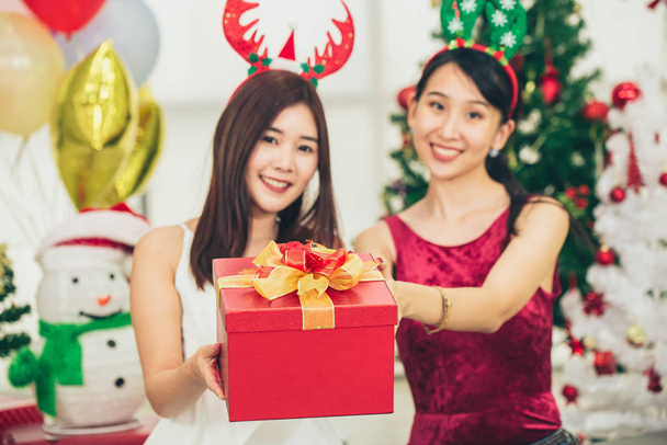Two Asian girls teen in happiness Christmas New Year Eve moment cellebration give the Gift box. - Photo, Image