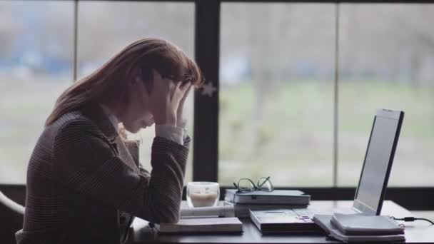 portrét unavené dívky, obchodní žena je nervózní kvůli tvrdé práci on-line sedí u stolu u okna v drahé restauraci během přestávky na kávu - Záběry, video