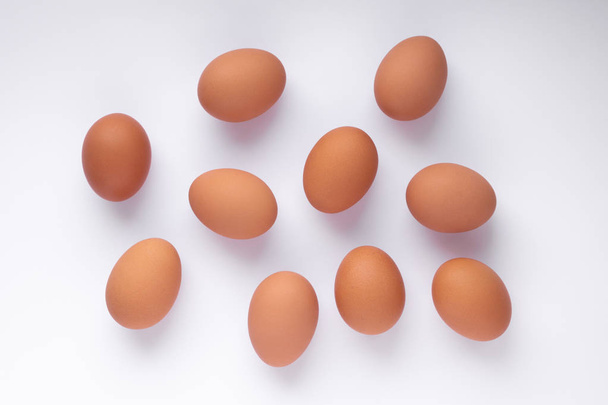 several chicken brown eggs lie on a white surface, top view - Photo, Image