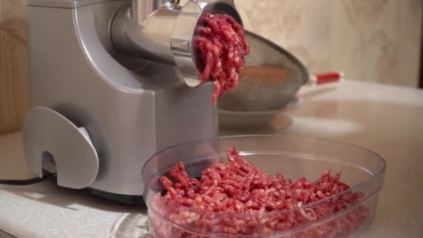 Zubereitung von Rinderhackfleisch mit einem elektrischen Fleischwolf. rohes Fleisch im Fleischwolf - Filmmaterial, Video