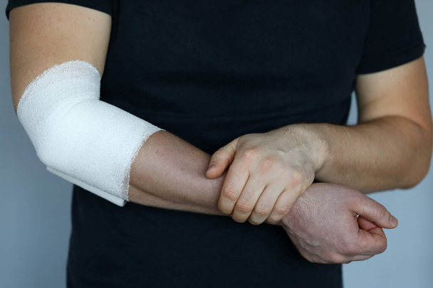 Mužská ruka s pevným elastickým obvazem na lokti detailní up - Fotografie, Obrázek