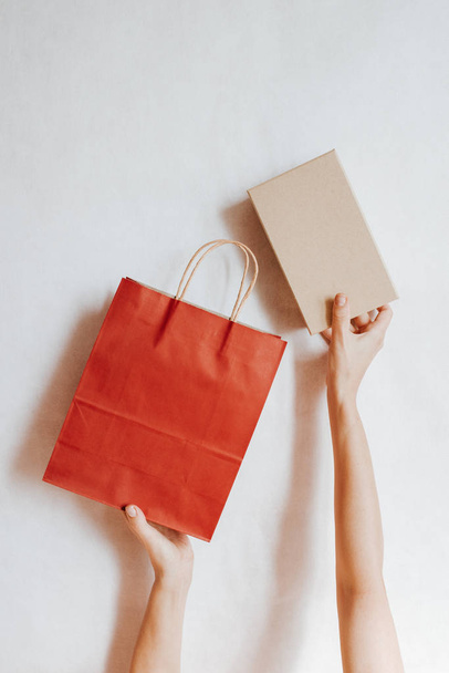 Happy woman holding in hand shopping package and box. Paper bag. Sale store. Beautiful girl in fashion shop. Customer buy present. Black friday sale. Holiday special offer, discount. Female in market - Zdjęcie, obraz