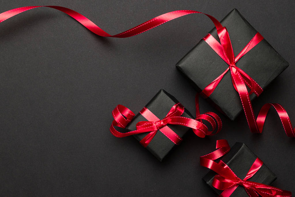 Karácsonyi háttér. Piros karácsonyi ajándékok, díszek fekete háttér felülnézet. Téli karácsonyi ajándék. Boldog karácsonyt és boldog ünnepeket üdvözlőlap, keret, banner. Újév. Noel vagyok. Lapos fektetés - Fotó, kép