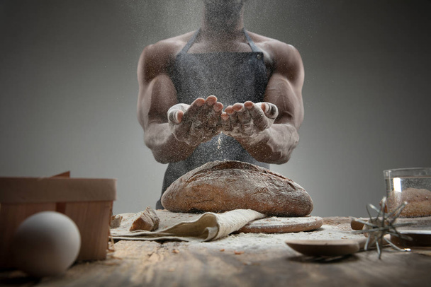 Primer plano de hombre afroamericano cocina pan en cocina artesanal
 - Foto, Imagen