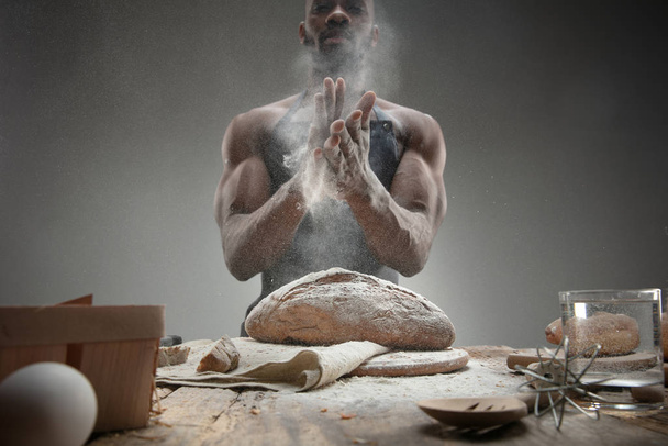 Close up of african-american man cooks bread at craft kitchen - Foto, Imagen