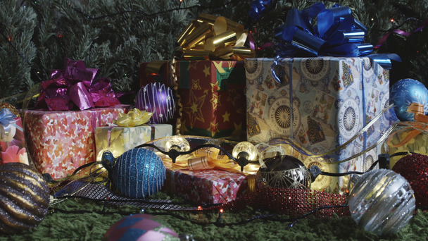 Family Holiday Traditions. The camera moves slowly along a variety of gift boxes decorated with glittering bows, Christmas tree decorations and sparkling garlands - Filmati, video