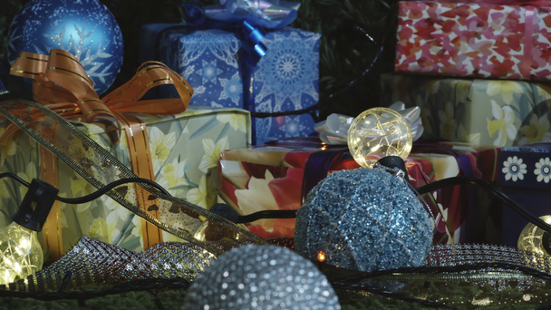 Gifts Under the Christmas Tree are Waiting. The camera moves slowly along a variety of gift boxes decorated with glittering bows, Christmas tree decorations and sparkling garlands - Záběry, video