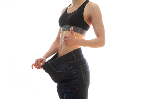 ダイエットと減量の概念。白い背景に大きなジーンズの女性 - 写真・画像