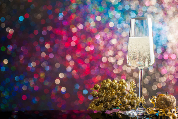 Egy pohár pezsgő körül karácsonyi díszek ellen - Fotó, kép