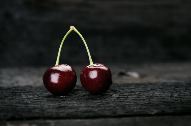 Cherries on a black table.. Natural wooden burnt table. Fresh food concept. Fruit. Summer time - Foto, Imagem