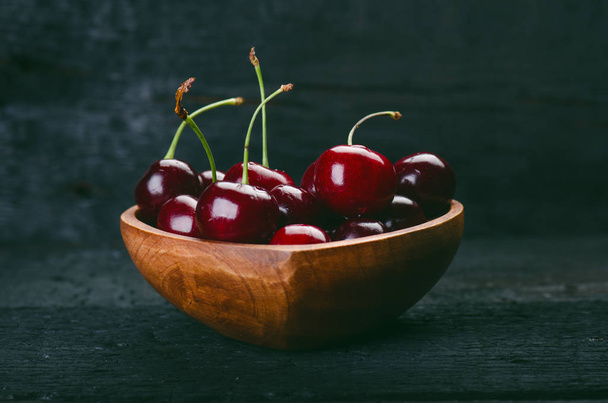Cherries on a black table.. Natural wooden burnt table. Fresh food concept. Fruit. Summer time - Foto, Bild