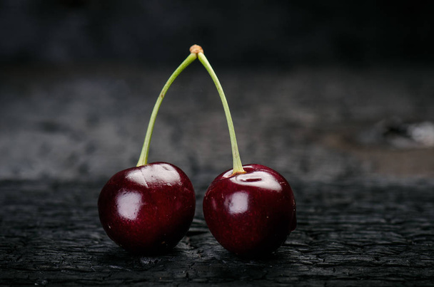 Cherries on a black table.. Natural wooden burnt table. Fresh food concept. Fruit. Summer time - Фото, изображение