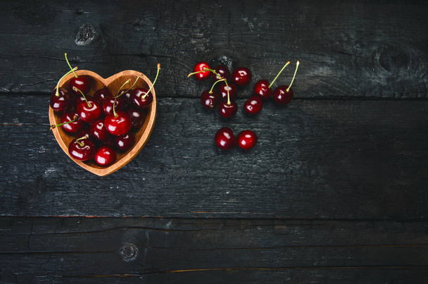 Cherries on a black table.. Natural wooden burnt table. Fresh food concept. Fruit. Summer time - Foto, Imagen