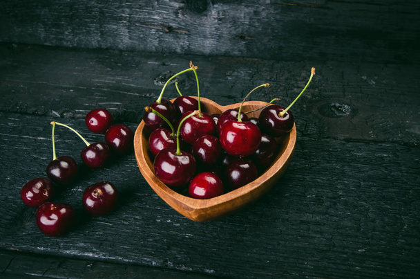 Cherries on a black table.. Natural wooden burnt table. Fresh food concept. Fruit. Summer time - Фото, зображення