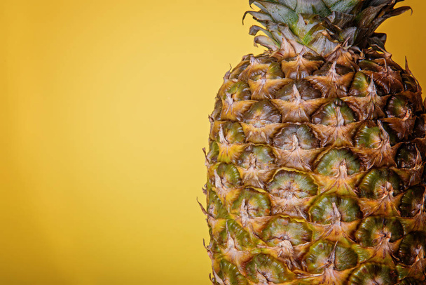 Ripe pineapple on a yellow background. - Photo, image