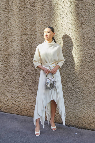 Woman with long pleated skirt and sweater before Salvatore Ferragamo fashion show, Milan Fashion Week street style  - Фото, изображение